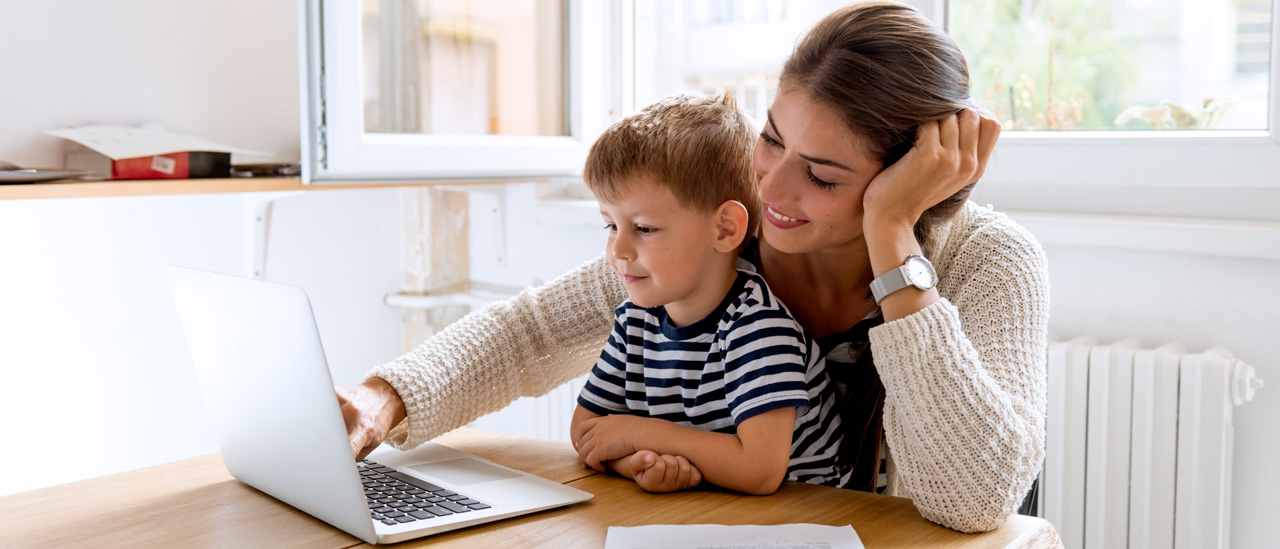 Woman and child viewing a laptop with a smile
